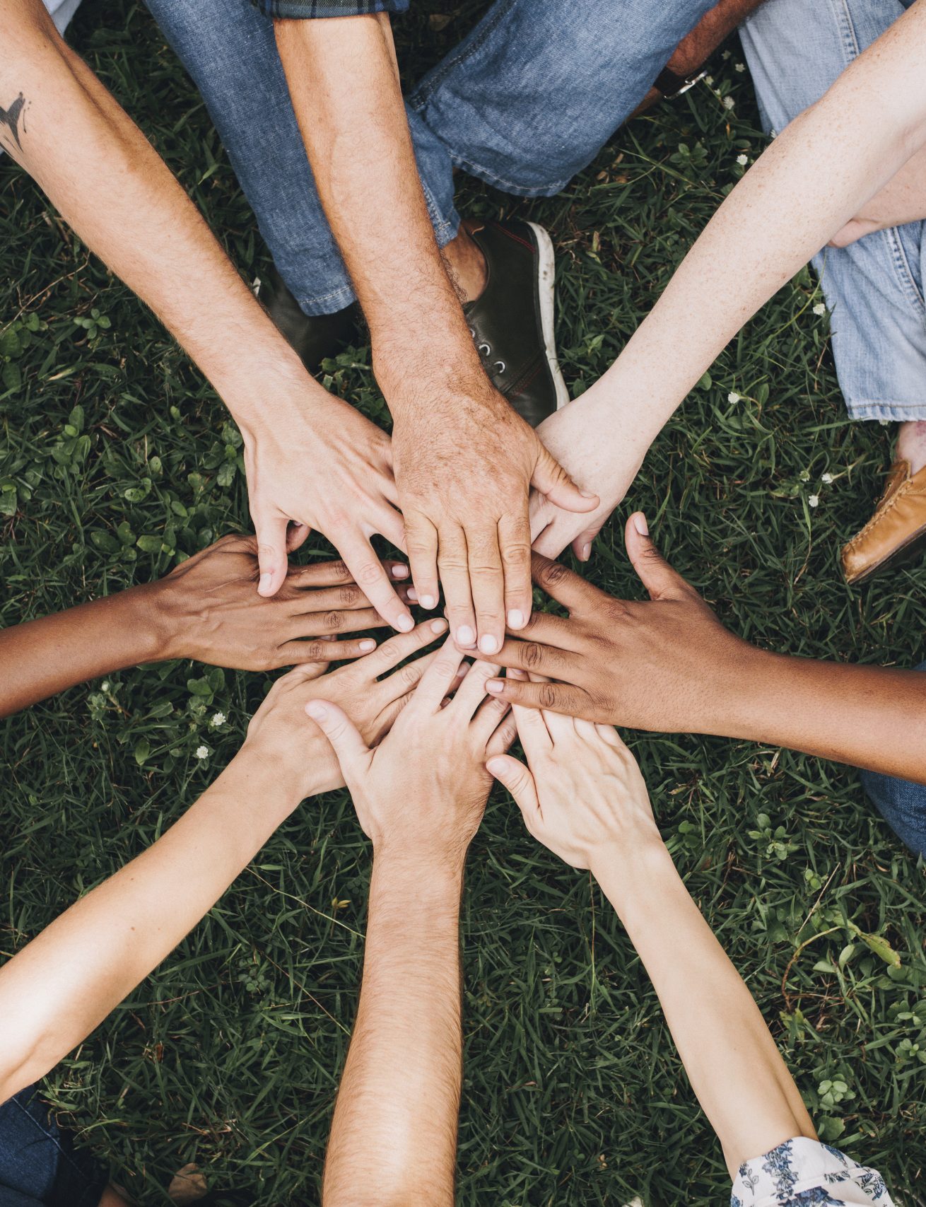 People stacking hands together in the park